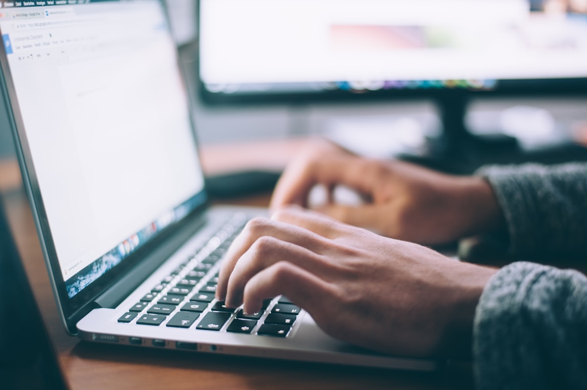 Canadian man reading Bible at kitchen table with laptop open to TFSA investment account, beginner investing guide